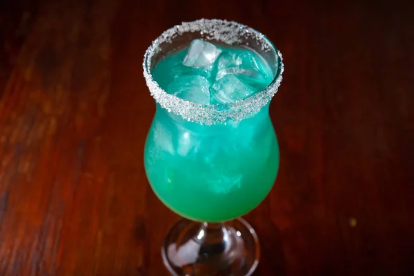 Refreshing sea blue cocktail on a wooden background
