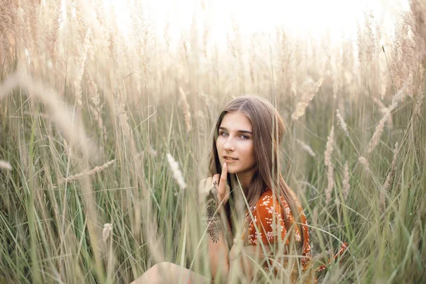 Girl in a red dress on a wheat field — Stockfoto