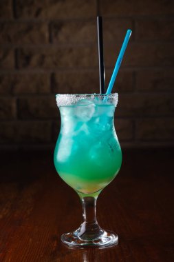 Ahşap arka planda taze deniz mavisi kokteyli.