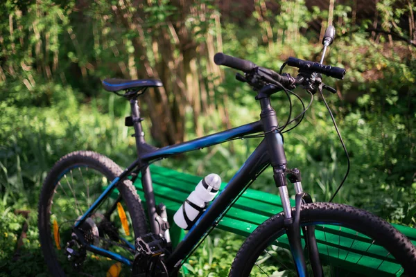 Deportes bicicleta negra en el parque cerca de los bancos con fondo borroso —  Fotos de Stock