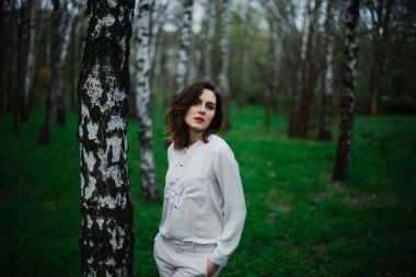 Güzel genç kız bahar parkında dinleniyor ve baharın tadını çıkarıyor.