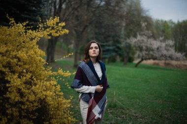 Güzel genç kız bahar parkında dinleniyor ve baharın tadını çıkarıyor.