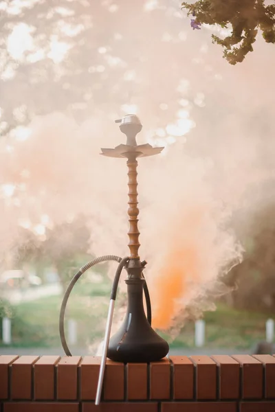 Hookah ao ar livre em um fundo de fumaça colorida — Fotografia de Stock