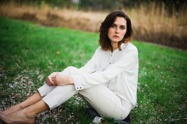 Güzel genç kız bahar parkında dinleniyor ve baharın tadını çıkarıyor.