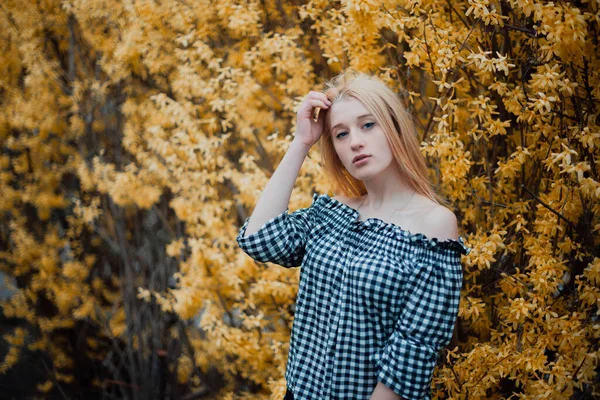 Menina loira bonita em um fundo de árvores floridas — Fotografia de Stock