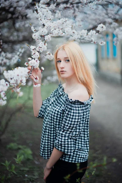 Красива молода блондинка на фоні квітучих дерев — стокове фото