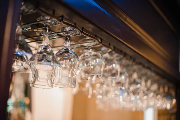 Vidrio gafas brillantes cuelgan en un mostrador de bar con fondo borroso — Foto de Stock