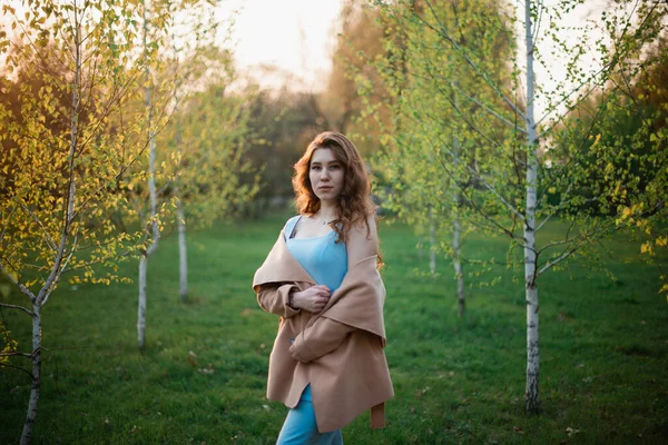 春の公園で青いドレスの美しい若い女の子 — ストック写真