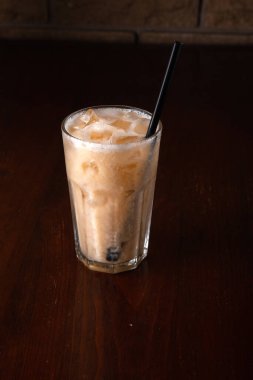 Ahşap zemin üzerinde buz olan muz kokteyli.