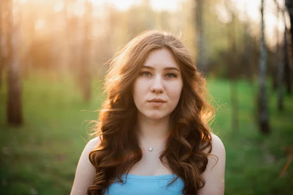 Hermosa joven en un vestido azul en un parque de primavera —  Fotos de Stock