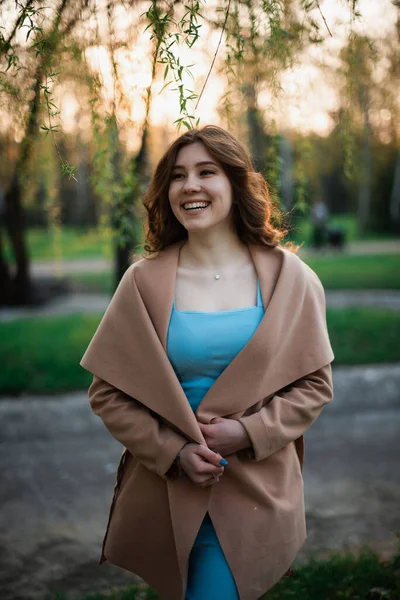 Menina bonita em um vestido azul em um parque de primavera — Fotografia de Stock