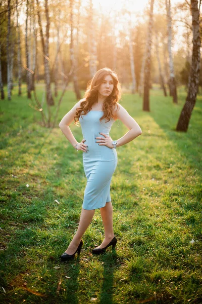 Красива молода дівчина в блакитній сукні в весняному парку — стокове фото
