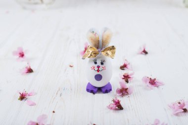 Beyaz ahşap arka planda yumurtaları olan Paskalya tavşanı.