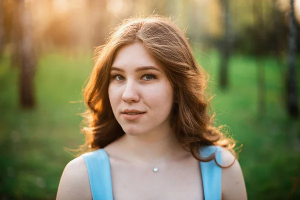 Beautiful young girl in a blue dress in a spring park — Stock Photo, Image