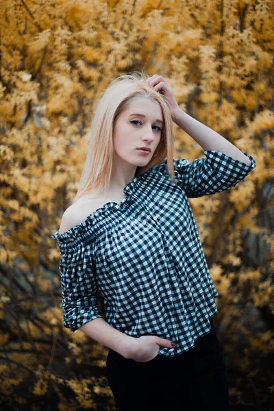 Beautiful young blonde girl on a background of flowering trees — Stok Foto