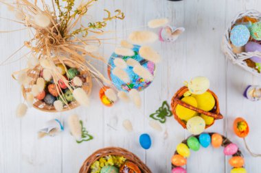 Beyaz ahşap arka planda sepette çok renkli Paskalya yumurtaları.