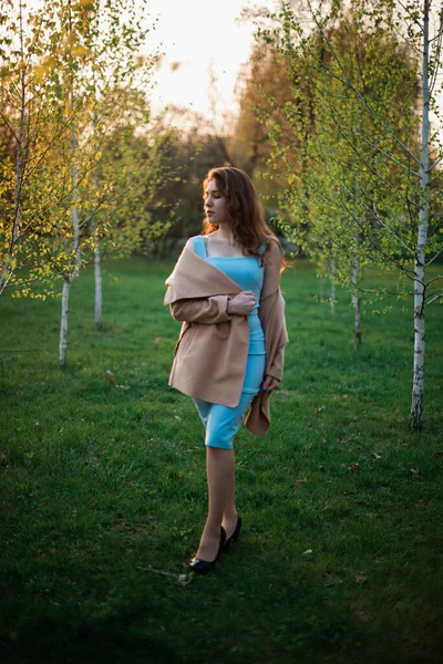 Menina bonita em um vestido azul em um parque de primavera — Fotografia de Stock