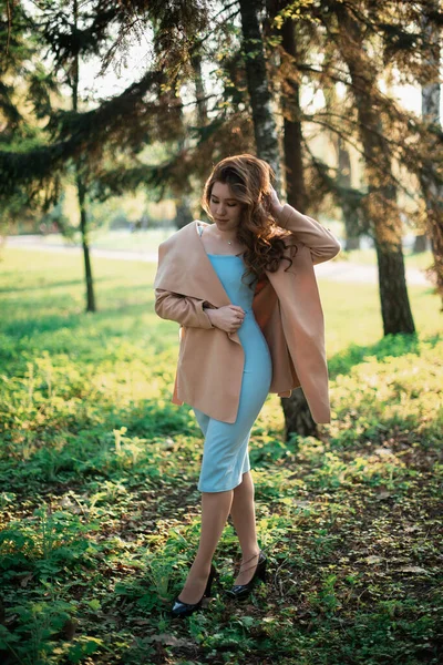 Menina bonita em um vestido azul em um parque de primavera — Fotografia de Stock