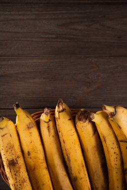 Tahta kahverengi arka planda muz sepeti.