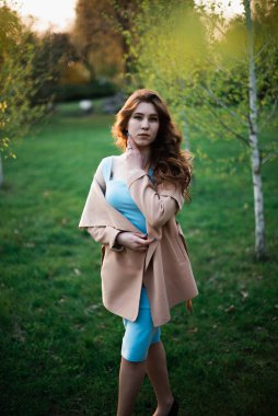 Bahar parkında mavi elbiseli güzel bir kız.