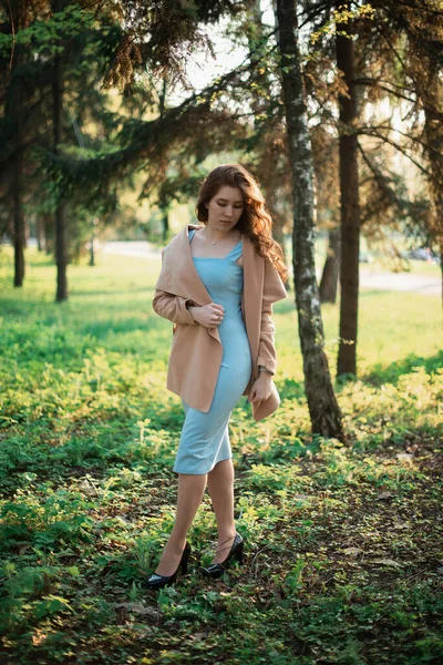 Vacker ung flicka i blå klänning i en vårpark — Stockfoto