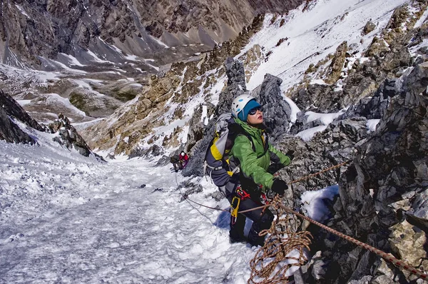 Альпинисты на маршруте, девушка в яркой куртке стоит не — стоковое фото