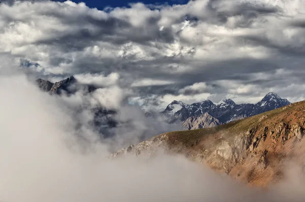 Muitas nuvens nas montanhas, névoa, paisagem montanhosa e neve — Fotografia de Stock