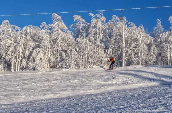 Skifahrer fährt in Skigebiet die Piste hinunter — Stockfoto