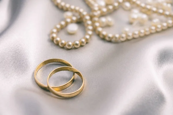 Anéis de casamento e colar de pérolas — Fotografia de Stock