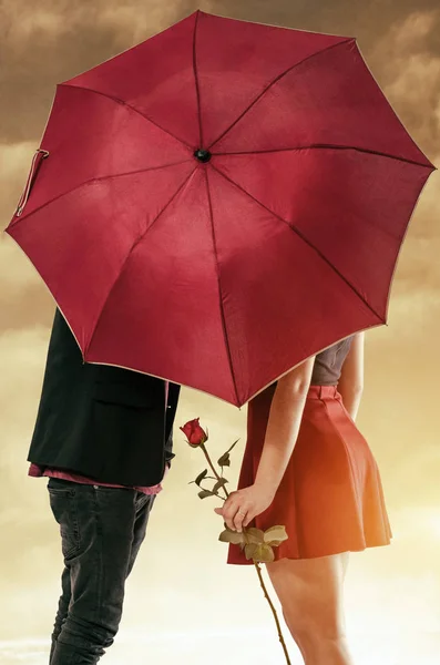 Paret gömmer sig bakom paraply — Stockfoto