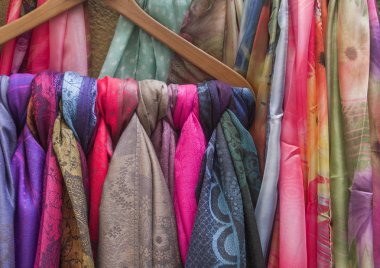 colorful scarfs hanged in store clipart