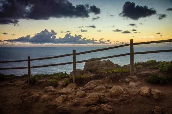 Klippor och staket i solnedgången — Stockfoto