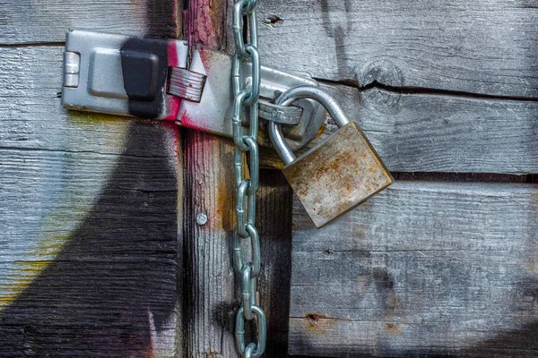 灰色の塗装とカラフルな落書きと南京錠で覆われた木製の門 — ストック写真