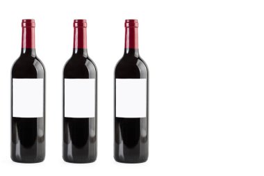 Beyaz arka planda üç şişe kırmızı şarap.
