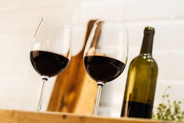 Tezgahta bir şişe şarap ve cam.