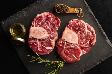 Siyah bir levhada çiğ osso buco.