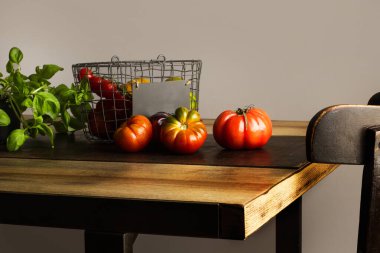 Tahta bir masada domates ve fesleğen.