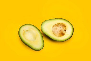 Sarı arka planda yarım avokado.