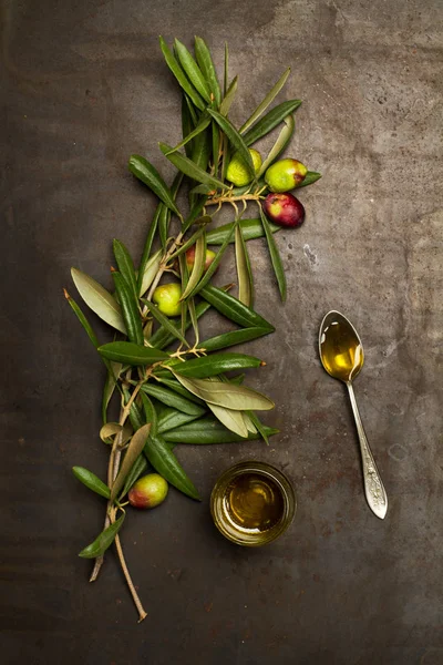 Paslanmış metal bir masanın üzerinde zeytinyağı ve yapraklı zeytin brunch 'ı.