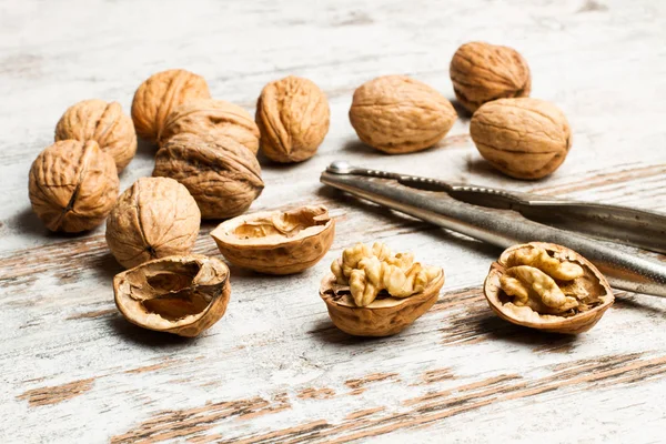 stock image Walnuts and a nutcracker on a rustic woden table 