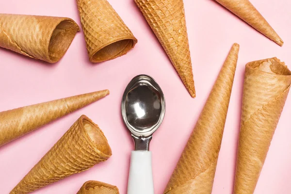 Ice cram cones and ice cream spoon on pink background