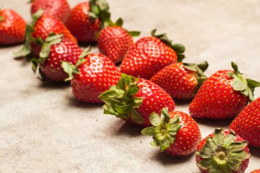 Mermer bir masada lezzetli kırmızı çilekler.