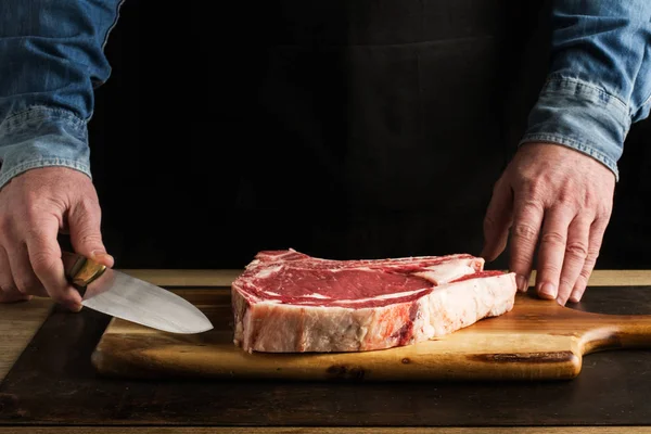 Hombre Con Cuchillo Mano Hueso Una Tabla Cocina Madera — Foto de Stock