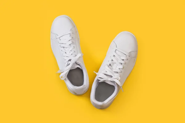 Ett Par Vita Sneakers Gul Bakgrund Ovanifrån — Stockfoto