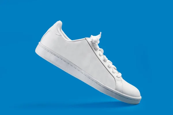 Mavi Arka Planda Beyaz Bir Spor Ayakkabı — Stok fotoğraf
