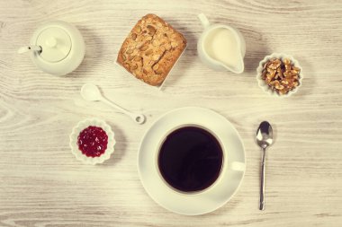 Kahvaltınız, ekmeğiniz ve reçeliniz beyaz ahşap bir masada.