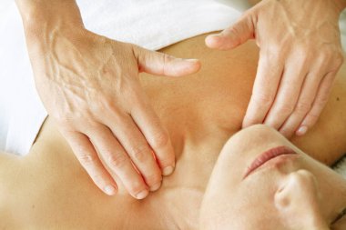 Sedyede yatan bir kadının boynundaki profesyonel masaj.