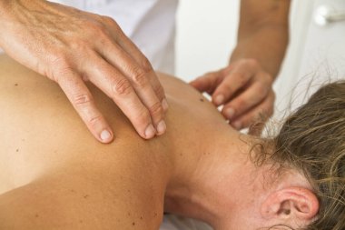 Boynunda ve sırtında bir kadına masaj ve osteopati.