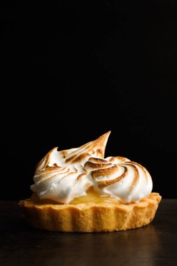 Koyu arkaplanda küçük bir limonlu turta 