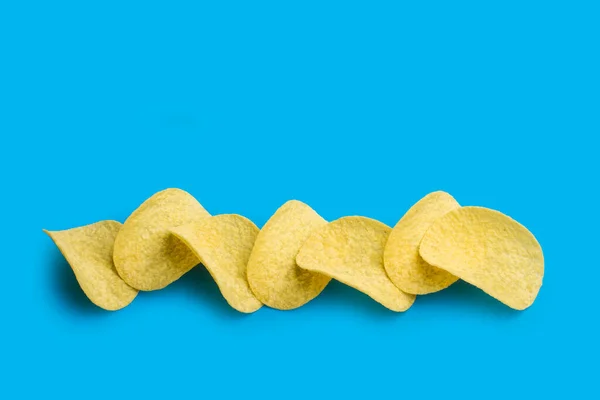 Eine Menge Kartoffelchips Einer Reihe Auf Blauem Hintergrund — Stockfoto